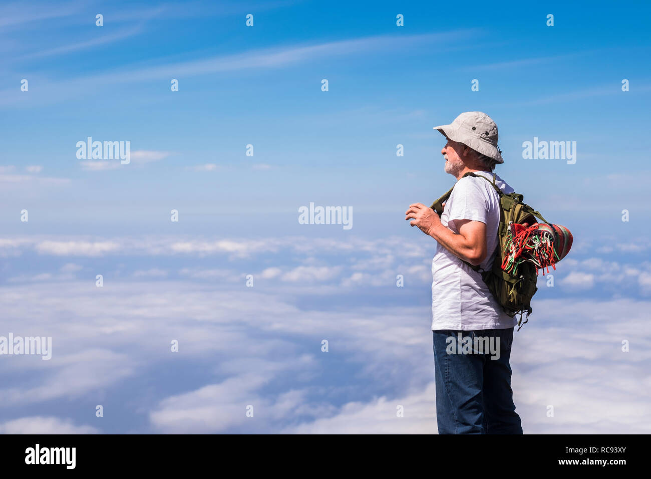Old silver societ white hair man standing and resting looking the blue sky infinite in front of him and enjoying the trekking travel - freedom third a Stock Photo