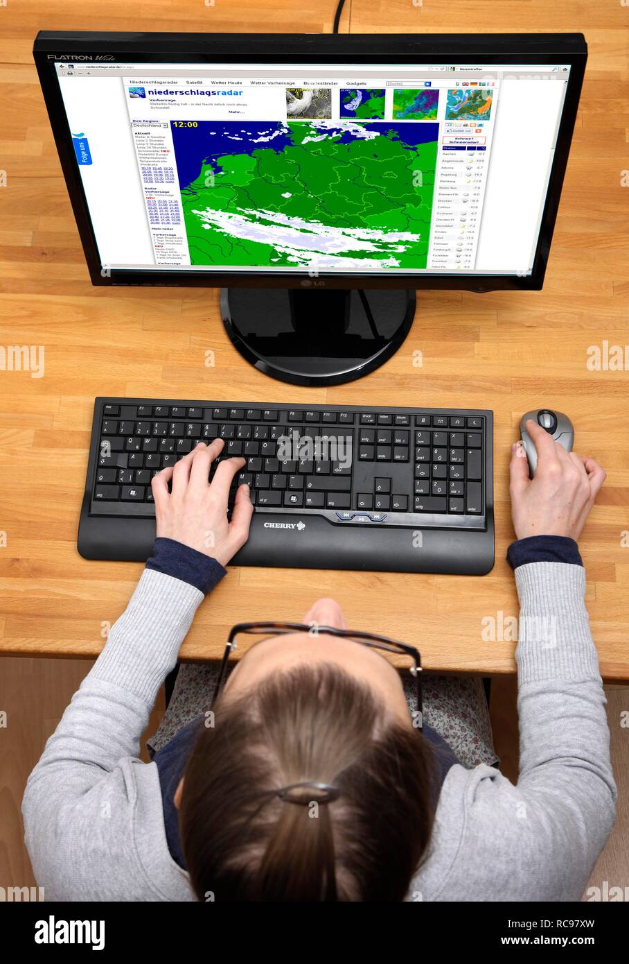 Woman surfing the internet with a computer, precipitation radar Stock Photo