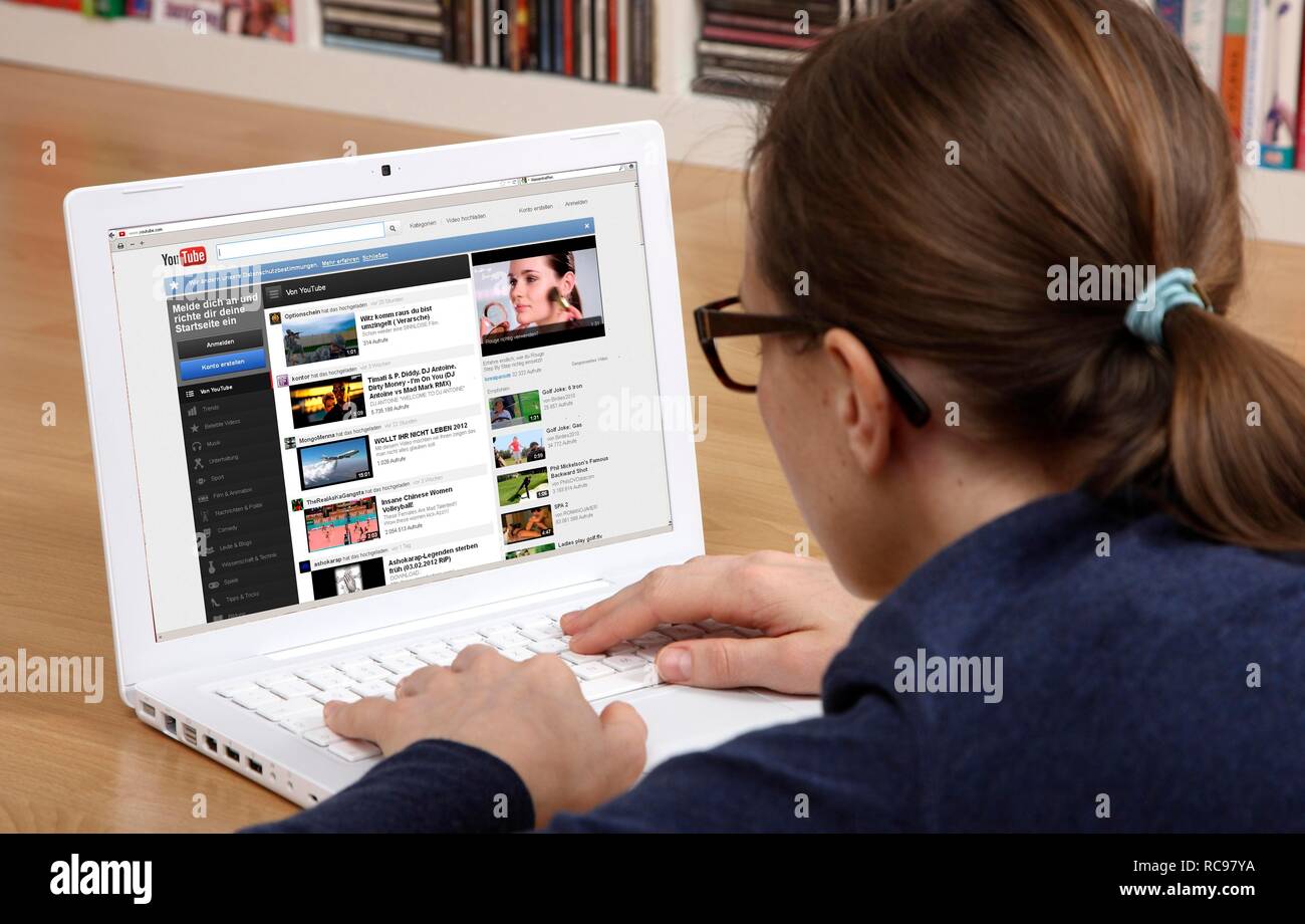 Woman surfing the internet with a laptop, YouTube, movies and video portal, uploading Stock Photo