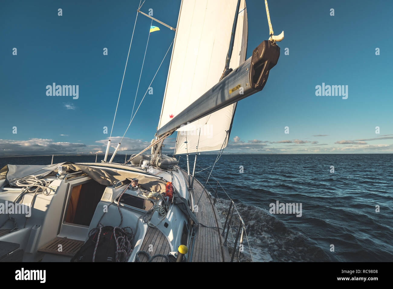 Closeup deck view. Yacht sailing next to the Northern Ireland shore. Boat equipment. The