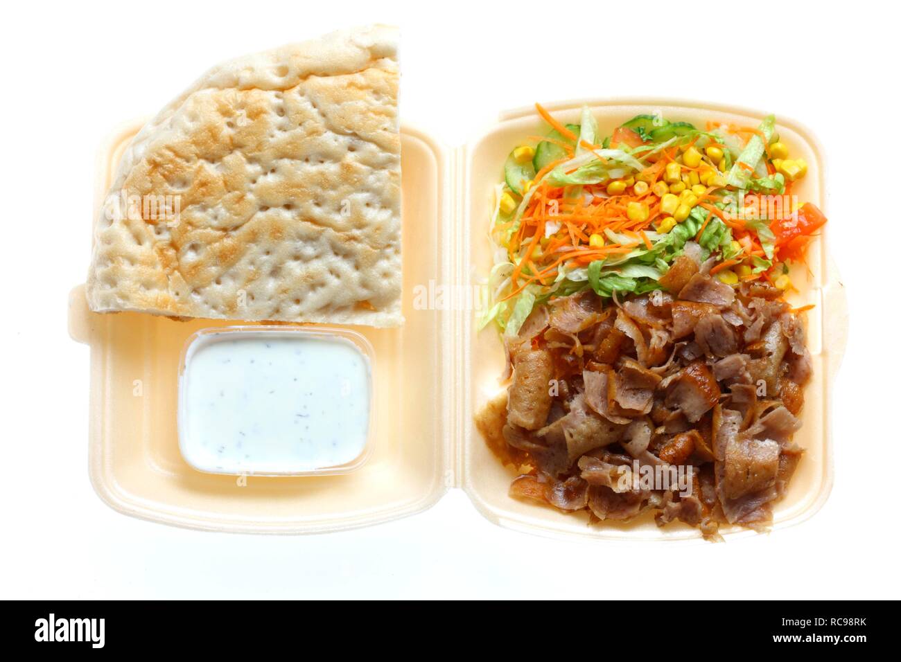 Fast food, doner kebab plate, with doner meat, salad, garlic-yogurt sauce and pita bread in plastic takeaway packaging Stock Photo