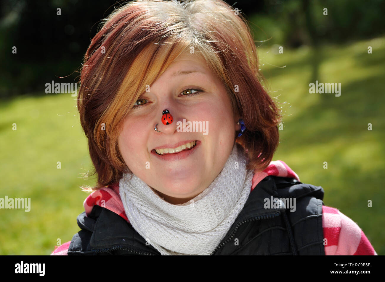 jungendliche Frau mit Marienkäfer auf der Nase | young woman having a beatle on her nose Stock Photo