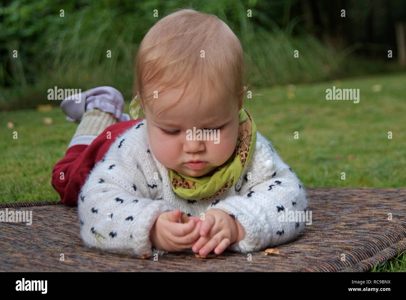 Kleinkind, Mädchen liegt auf der Wiese Stock Photo