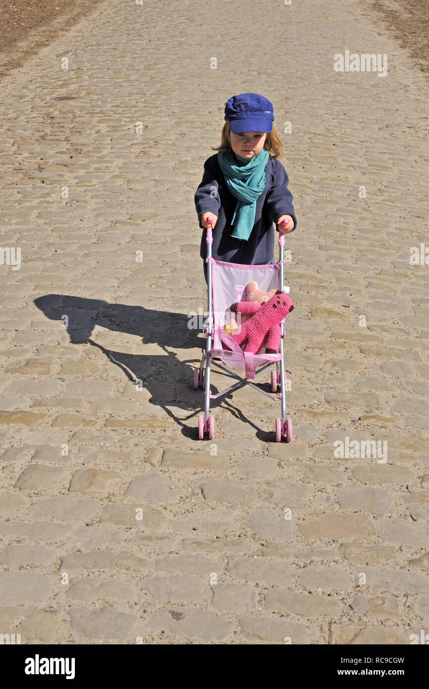 Kind mit Kinderwagen | Child with buggy Stock Photo