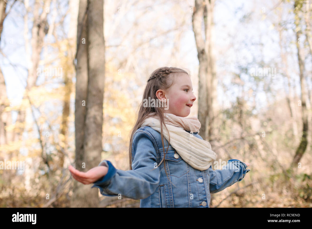 Little girl holding out hands in forest Stock Photo
