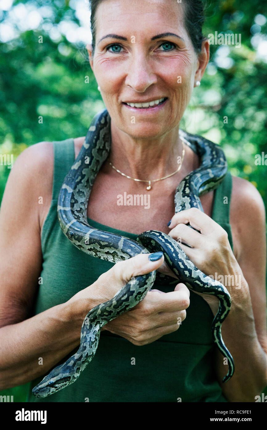 Mature woman with snake around neck Stock Photo