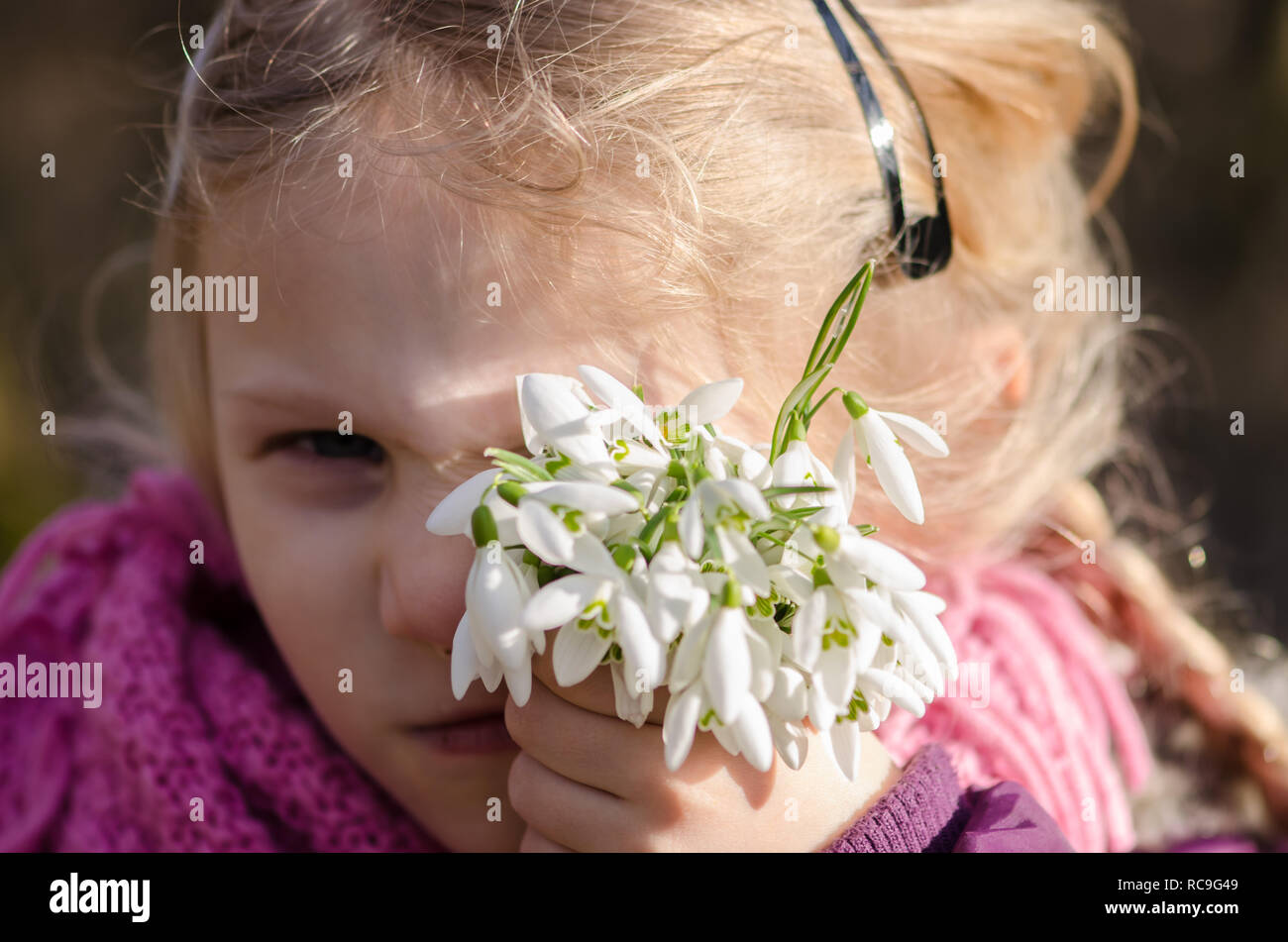 beautiful lovely girl with white snowdrop flowers in her hand Stock Photo