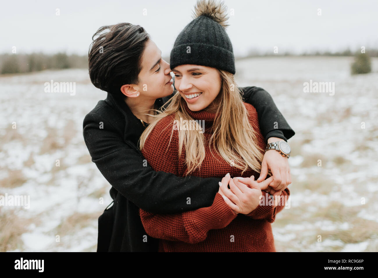 Couple hugging in snowy landscape, Georgetown, Canada Stock Photo