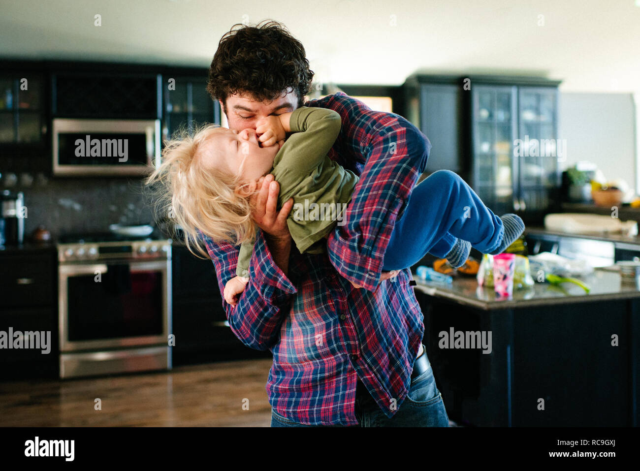 Father and son playing in kitchen Stock Photo