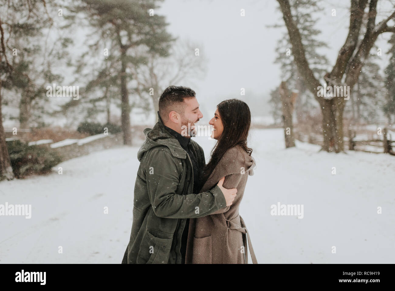 Couple hugging in snowy landscape, Georgetown, Canada Stock Photo