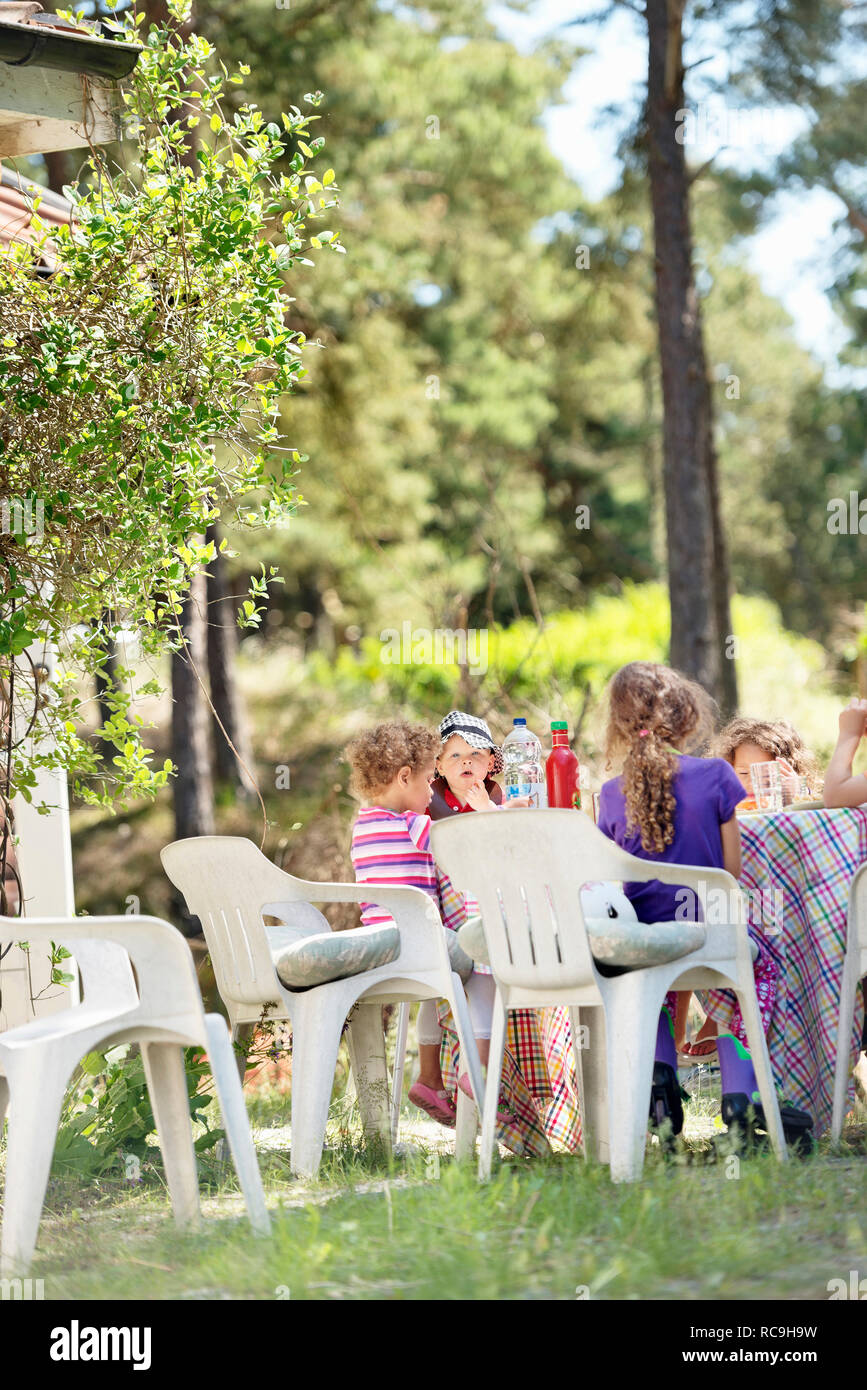 Children having meal in garden Stock Photo