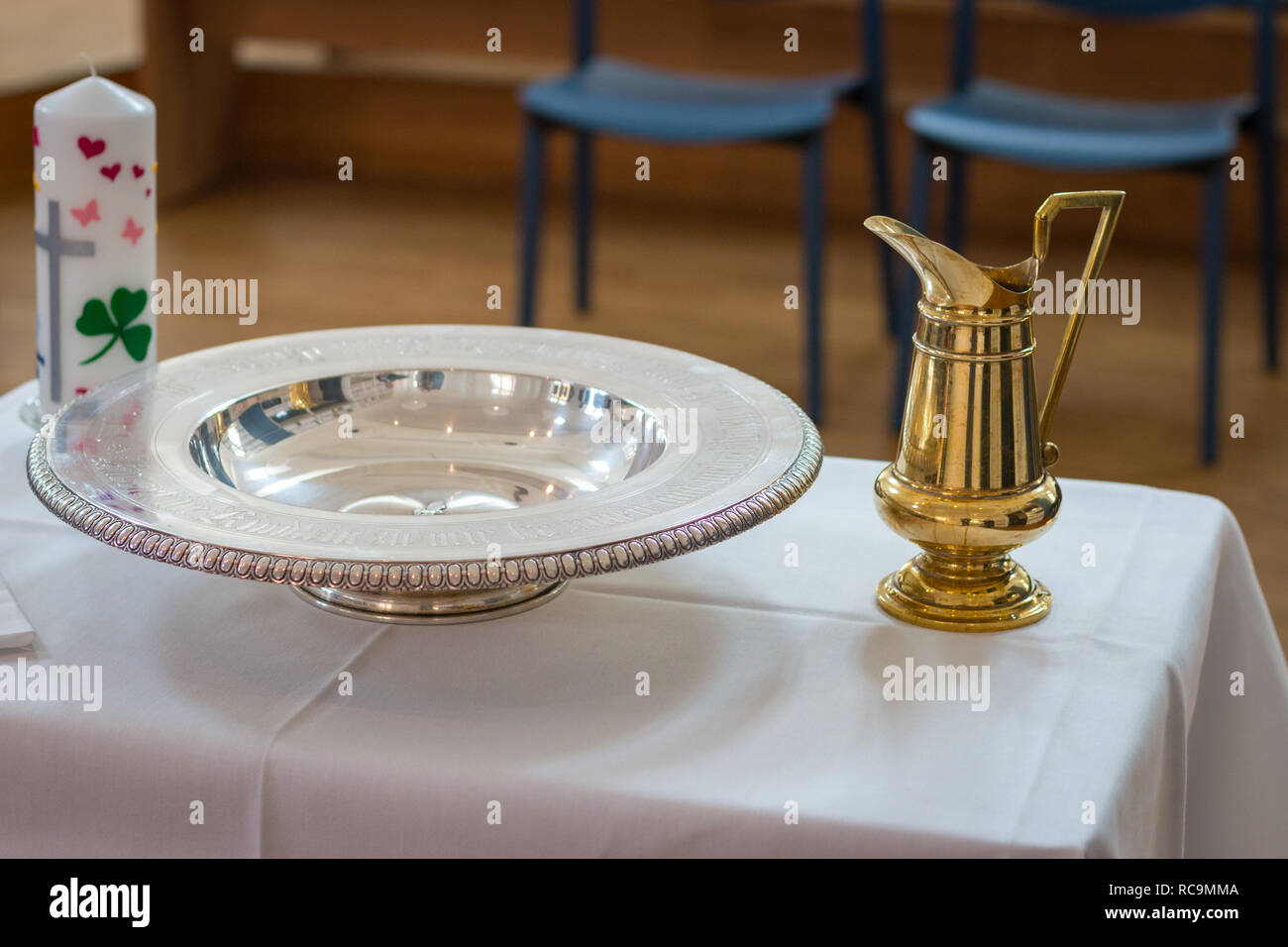 Prepared table for baptism with baptismal jug, bowl and candle Stock Photo Alamy
