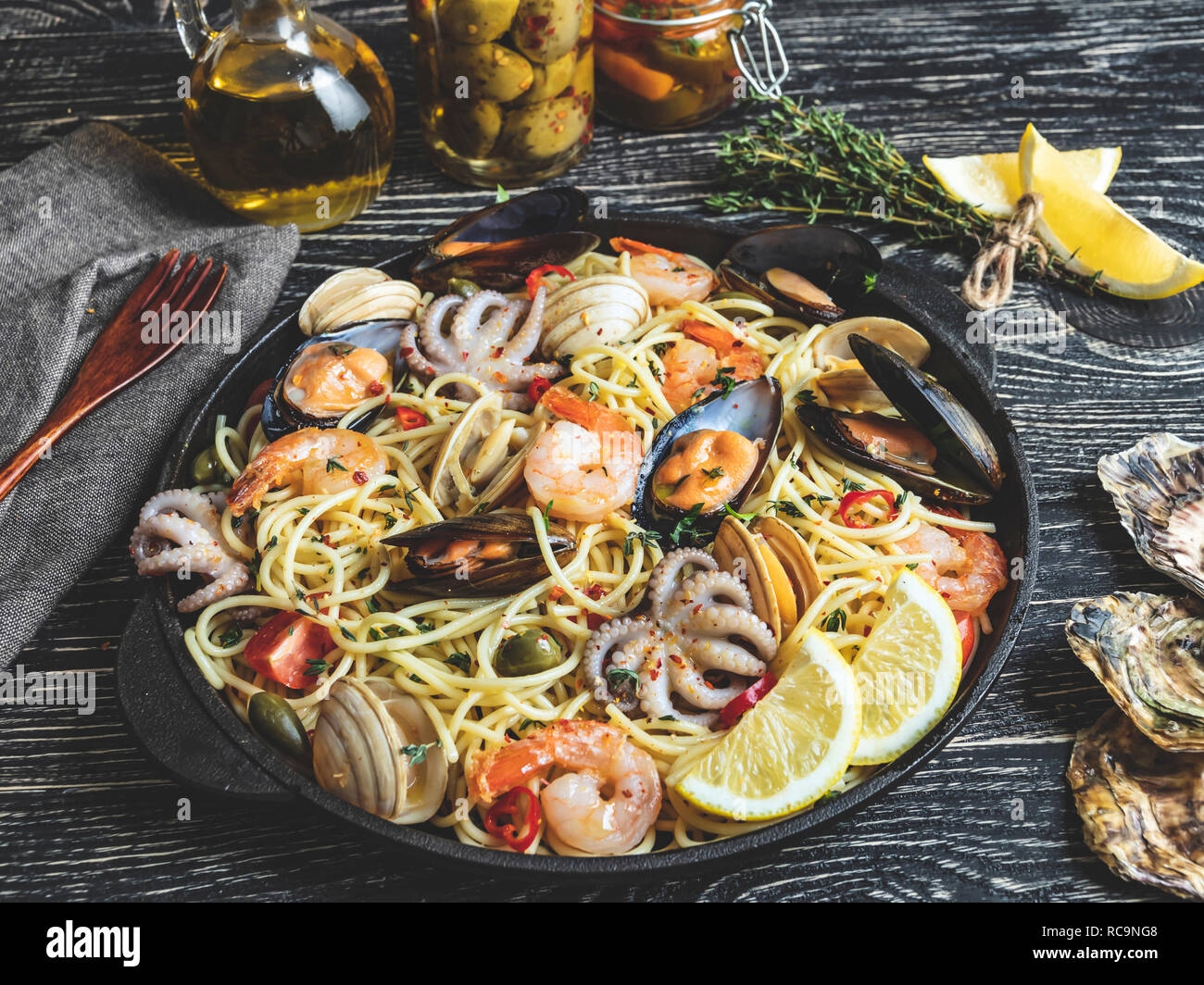 Cooked pasta with clams, shrimps, baby octopus, mussels tomato on a frying pan , spaghetti Stock Photo