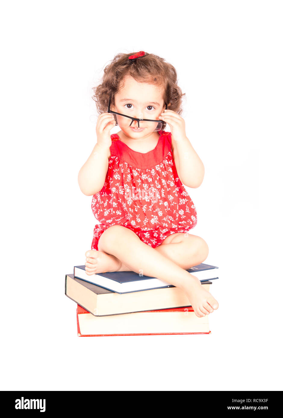 little girl sitting on books Stock Photo - Alamy