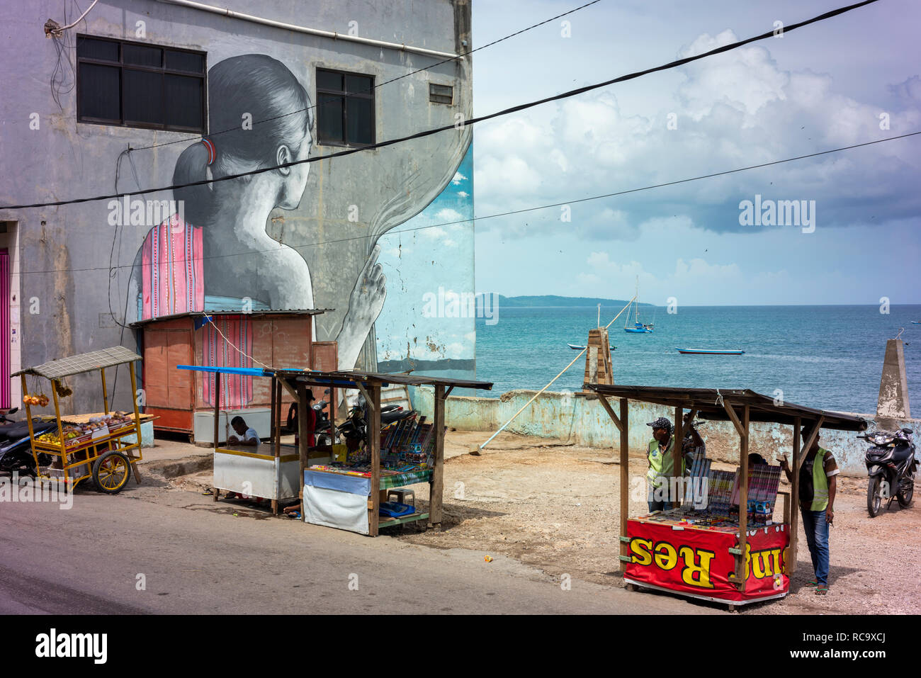 In central Kupang, a mural shows a young woman looking out over the ocean. Stock Photo