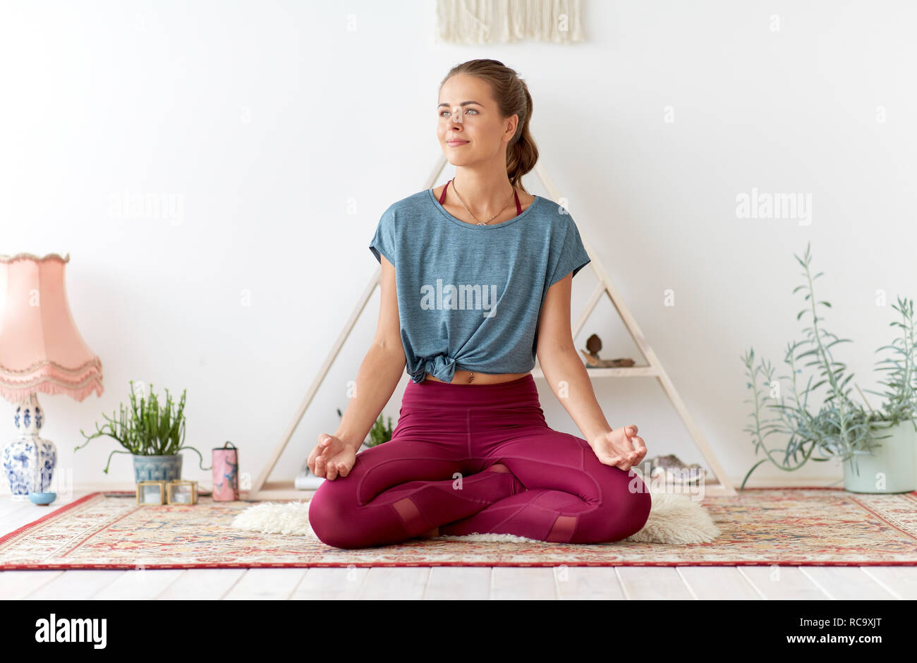 woman meditating in lotus pose at yoga studio Stock Photo - Alamy