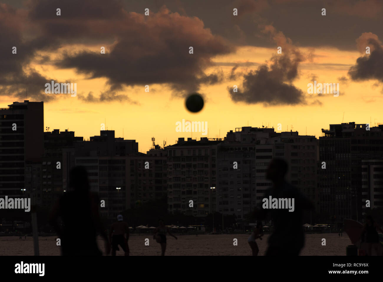 2019, january. Rio de Janeiro, Brazil. People playing football on the beach at the sunset, in Copacabana. Stock Photo