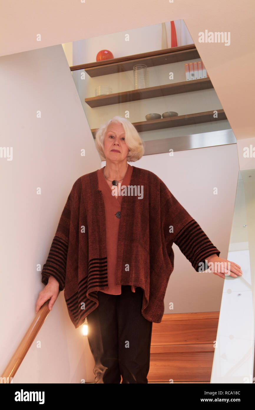 Frau mittleren Alters steht auf einer Treppe  | middleaged woman is standing on a staircase Stock Photo