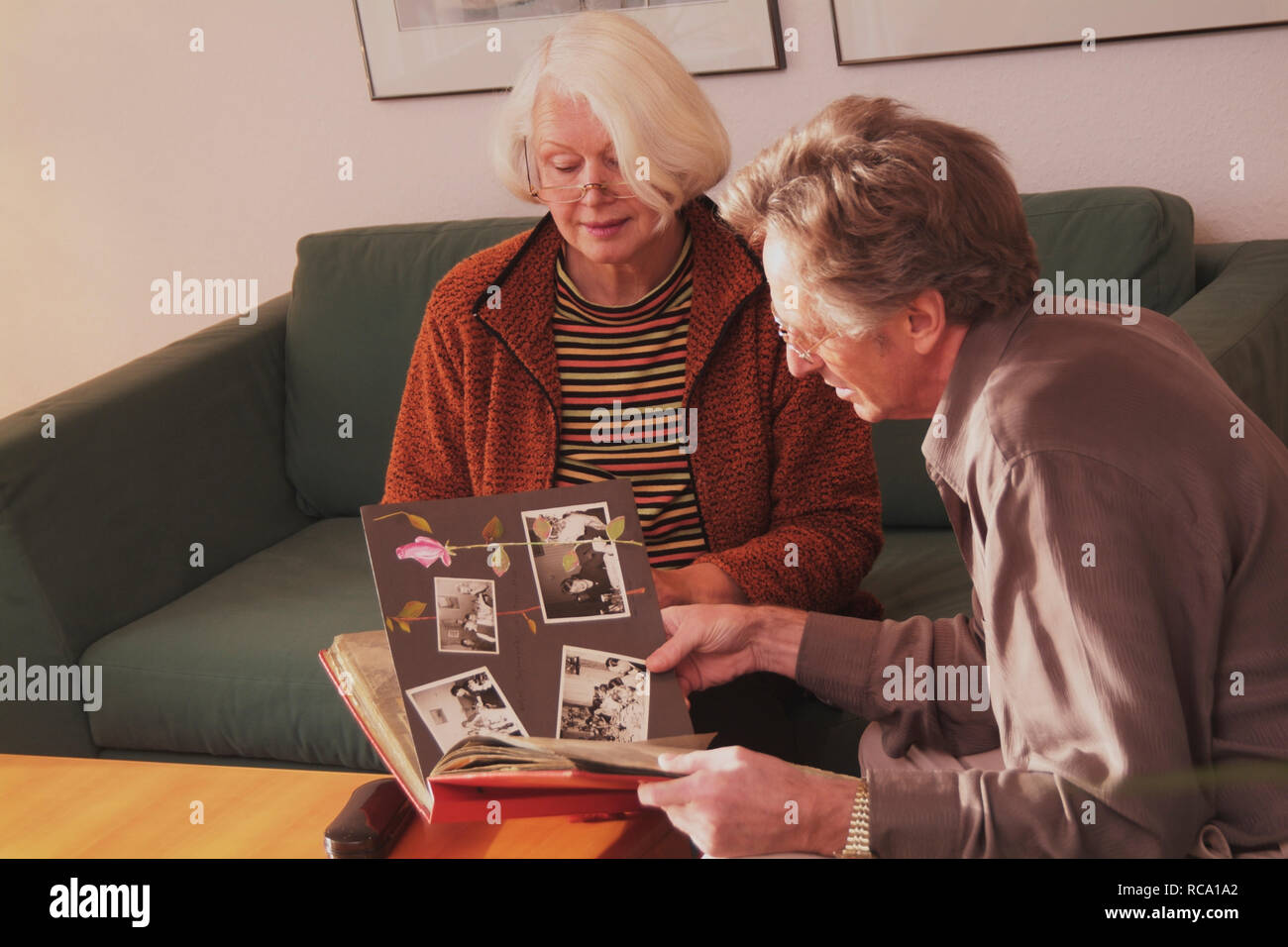 Pärchen mittleren Alters schaut sich Fotoalbum an  | middleaged couple is looking at photo album Stock Photo