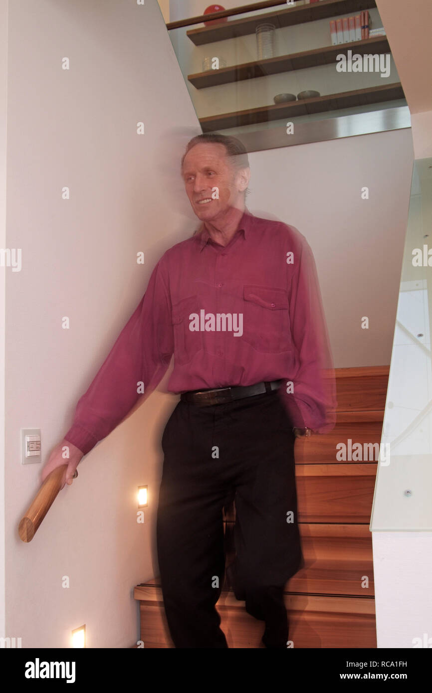 Mann mittleren Alters steht auf einer Treppe  | middleaged man is standing on a staircase Stock Photo