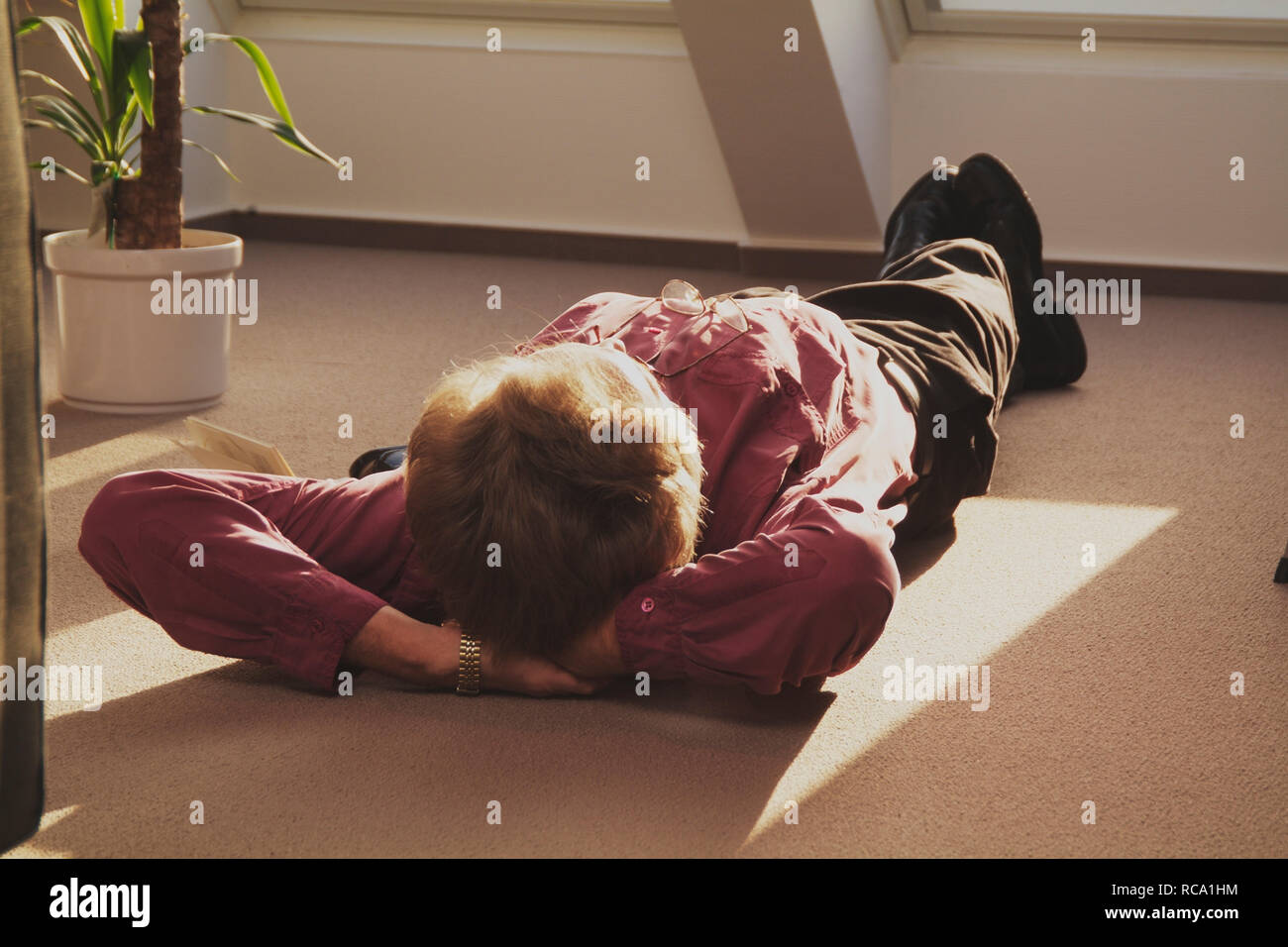 Mann mittleren Alters liegt auf dem Boden und entspannt | middleaged man is relaxing on the floor Stock Photo