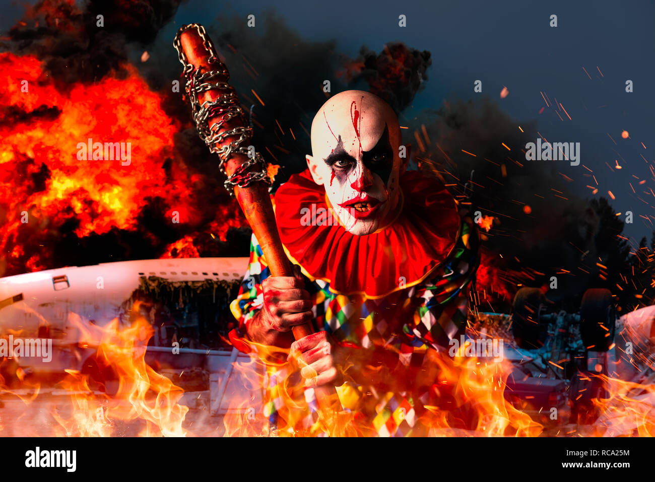 Crazy bloody clown with baseball bat, airplane in fire on background. Man  with makeup in halloween costume, scary killer Stock Photo - Alamy
