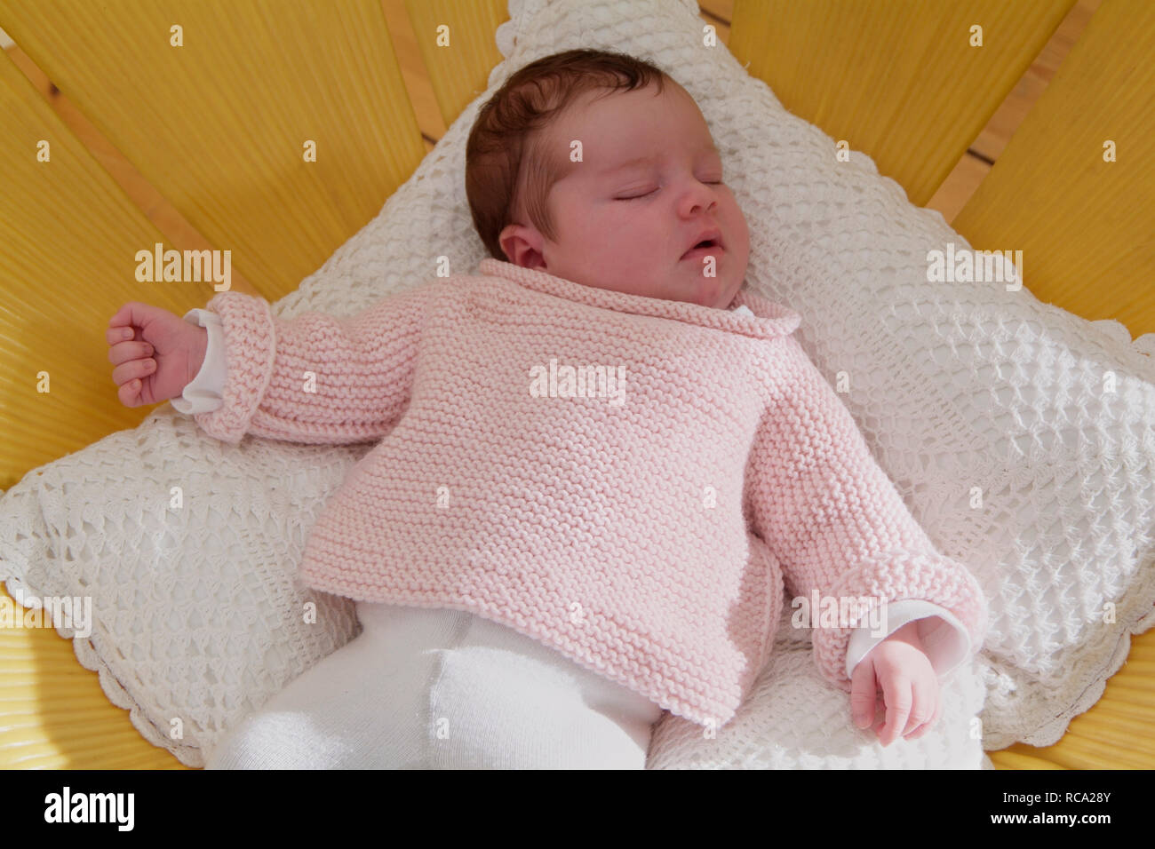 neugeborenes Baby liegt auf einem Kissen, das Kind ist 12 Tage alt | new born baby lying on a cushion - the baby ist 12 days old. Stock Photo