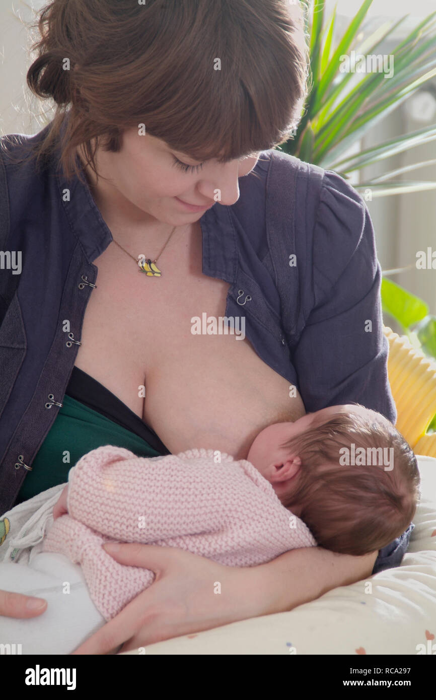 Junge Mutter stillt ihre neugeborene Tochter, das Kind ist 12 Tage alt | young mother nursing her new born baby - the baby ist 12 days old. child, chi Stock Photo