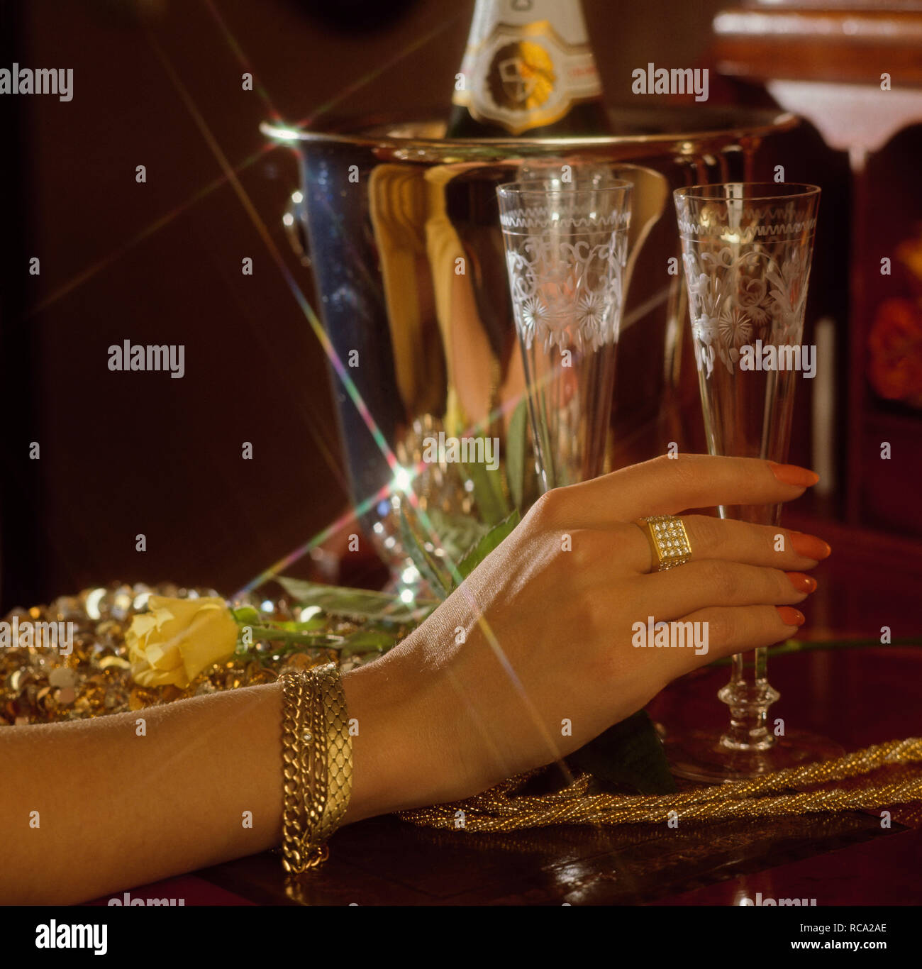Frauenhand berührt Sektglas, HG Sektkübel, festlich | female hand touching champagne glass, celebration, event *** Local Caption *** Modelrelease vorh Stock Photo