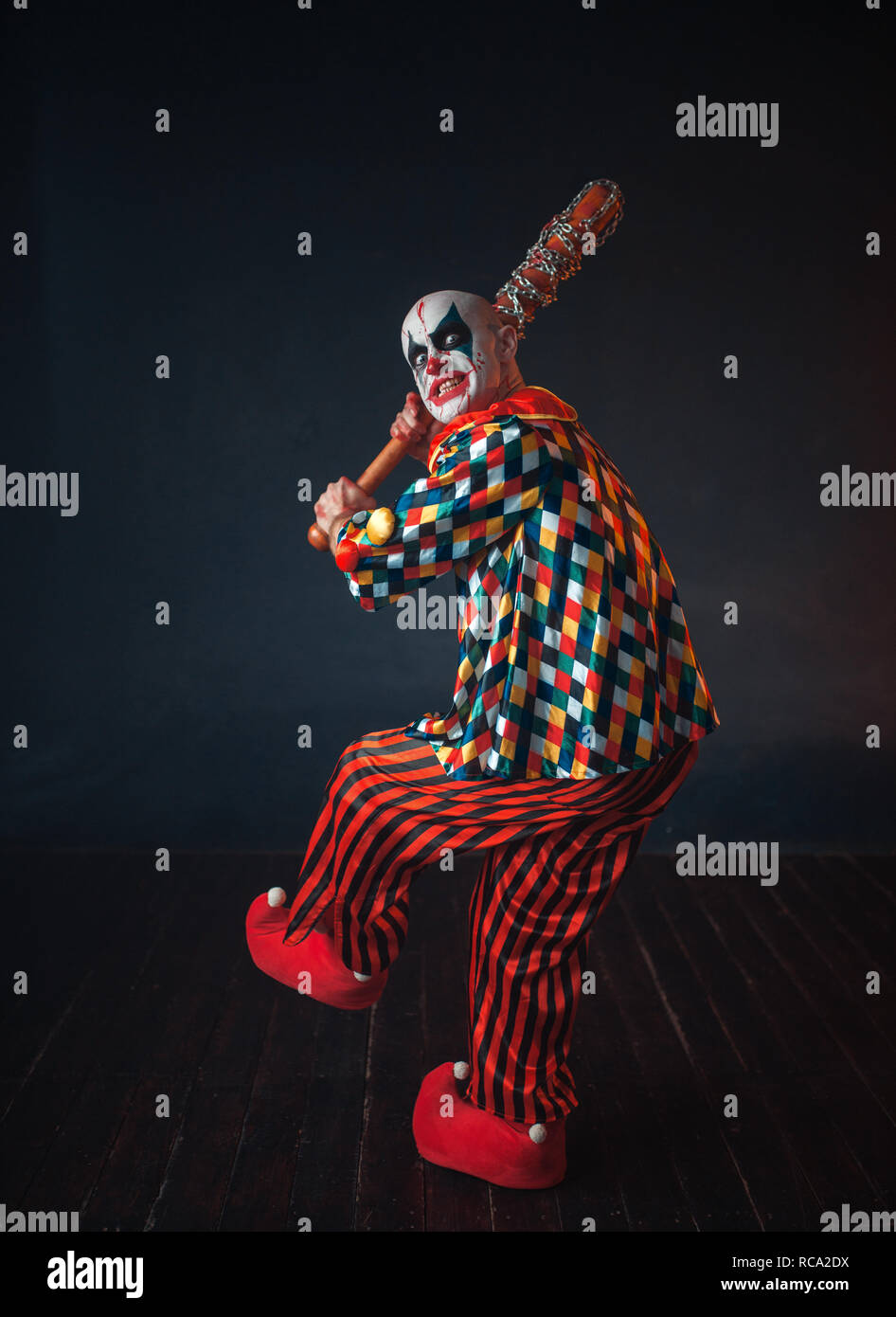 Scary bloody clown reaches out baseball bat. Man with makeup in halloween  costume, crazy killer Stock Photo - Alamy