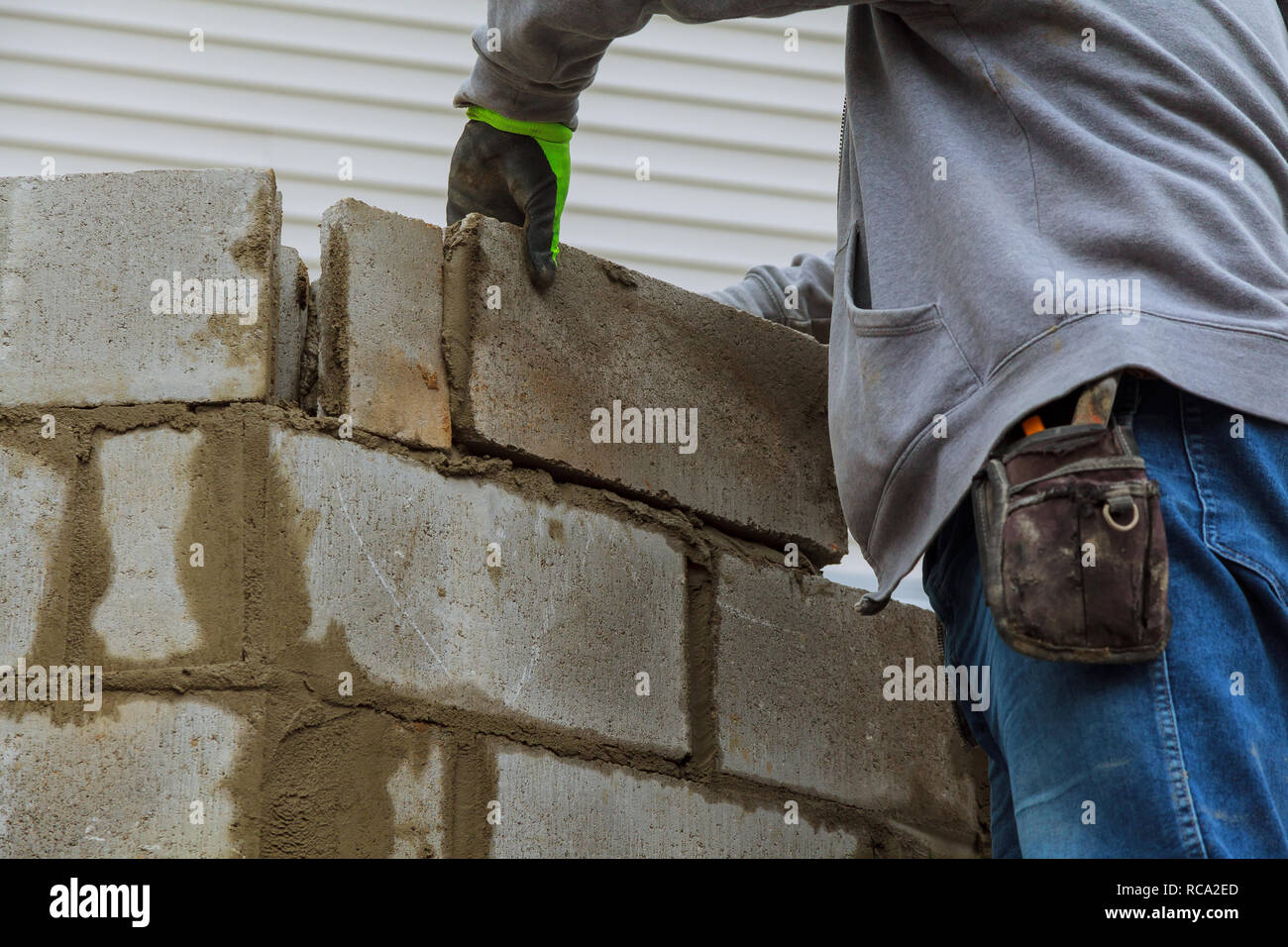 Worker installing cement block building a wall for a house Stock Photo