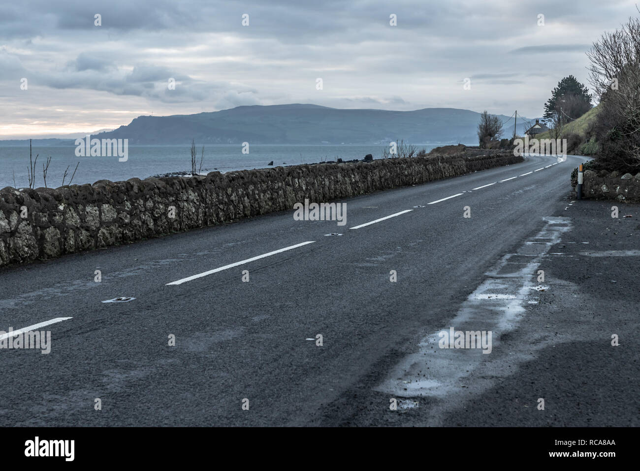 Sunrise in Carnlough bay with road and mountains, Antrim, Northern