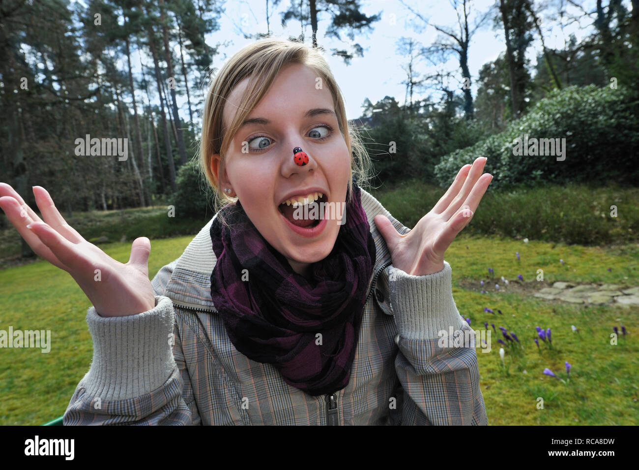 jungendliche Frau mit Marienkäfer auf der Nase | young woman having a beatle on her nose Stock Photo