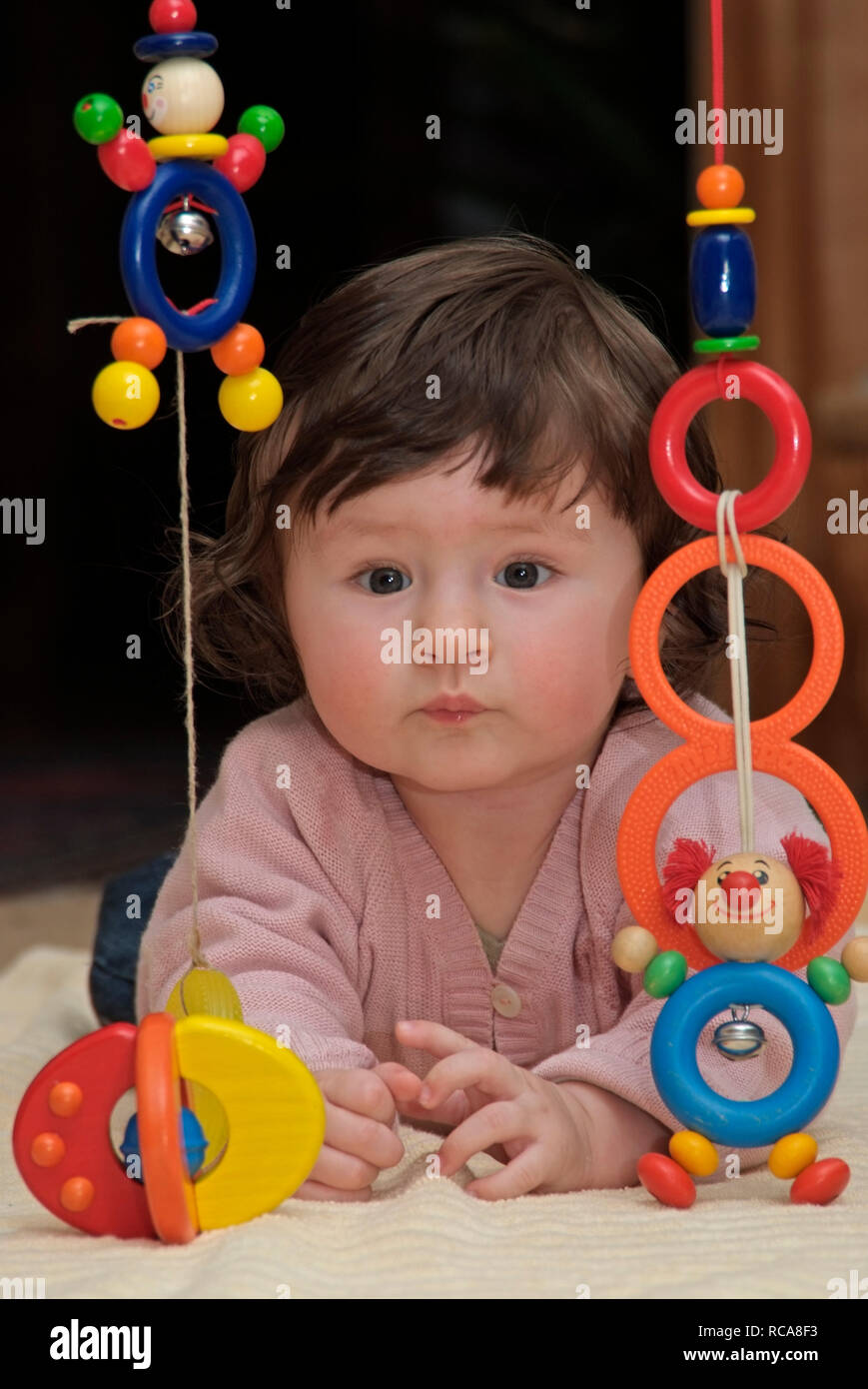 Baby im Zimmer liegt auf dem Boden, Spielzeug | baby lying in a room on the floor, playing with toys Stock Photo
