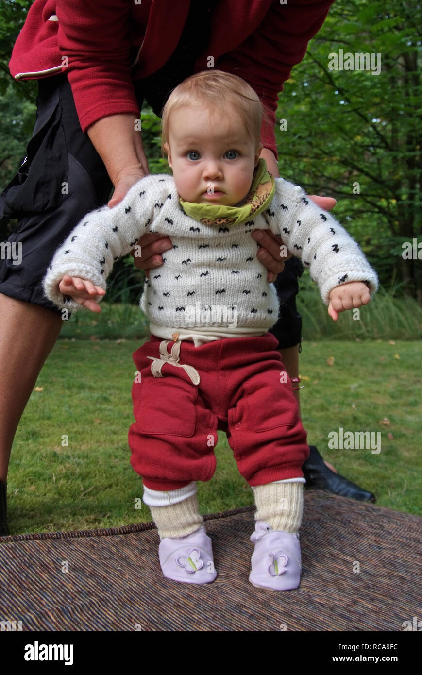 Baby im Freien lernt laufen | baby outside learns walking Stock Photo