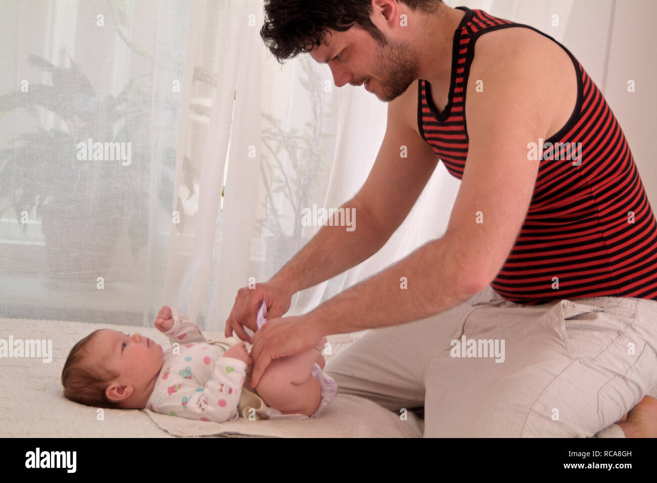 Vater kümmert sich um Säugling | father with baby taking care Stock Photo