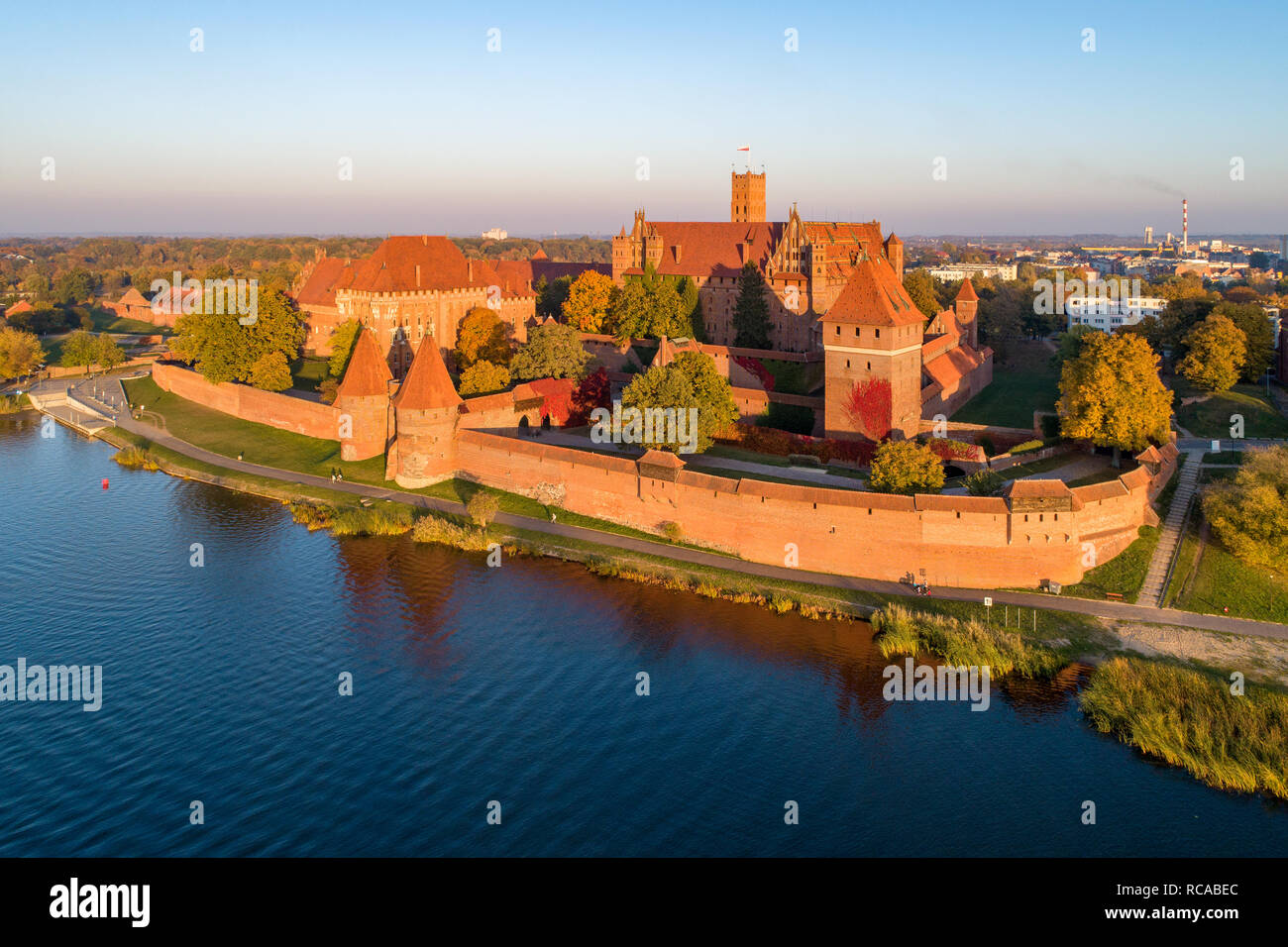 Medieval Malbork (Marienburg) Castle in Poland, main fortress of the Teutonic Knights at the Nogat river. Aerial view in fall in sunset light. Stock Photo
