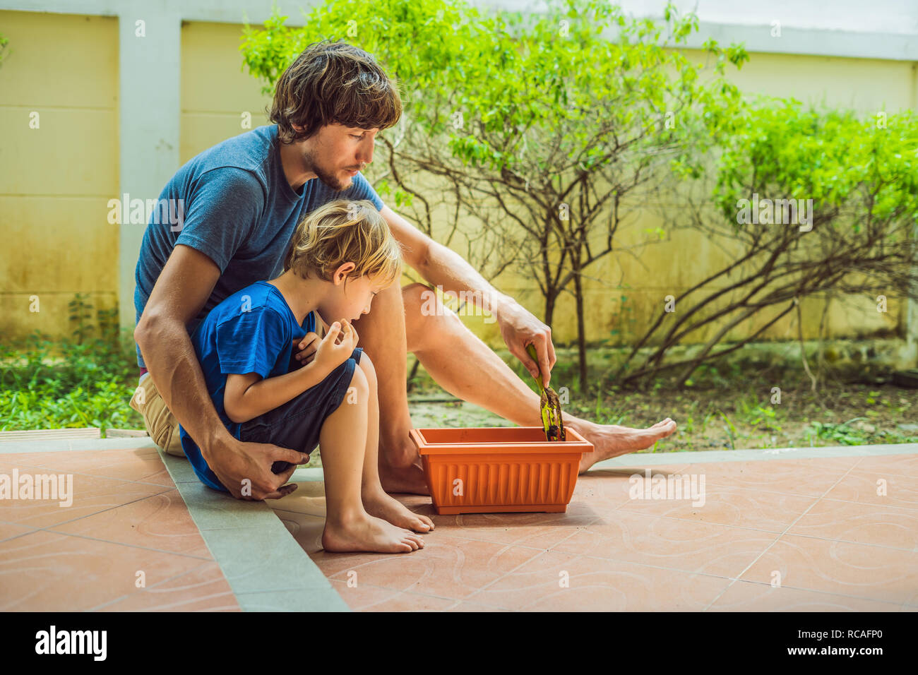 Father and son gardening in the garden near the house Stock Photo