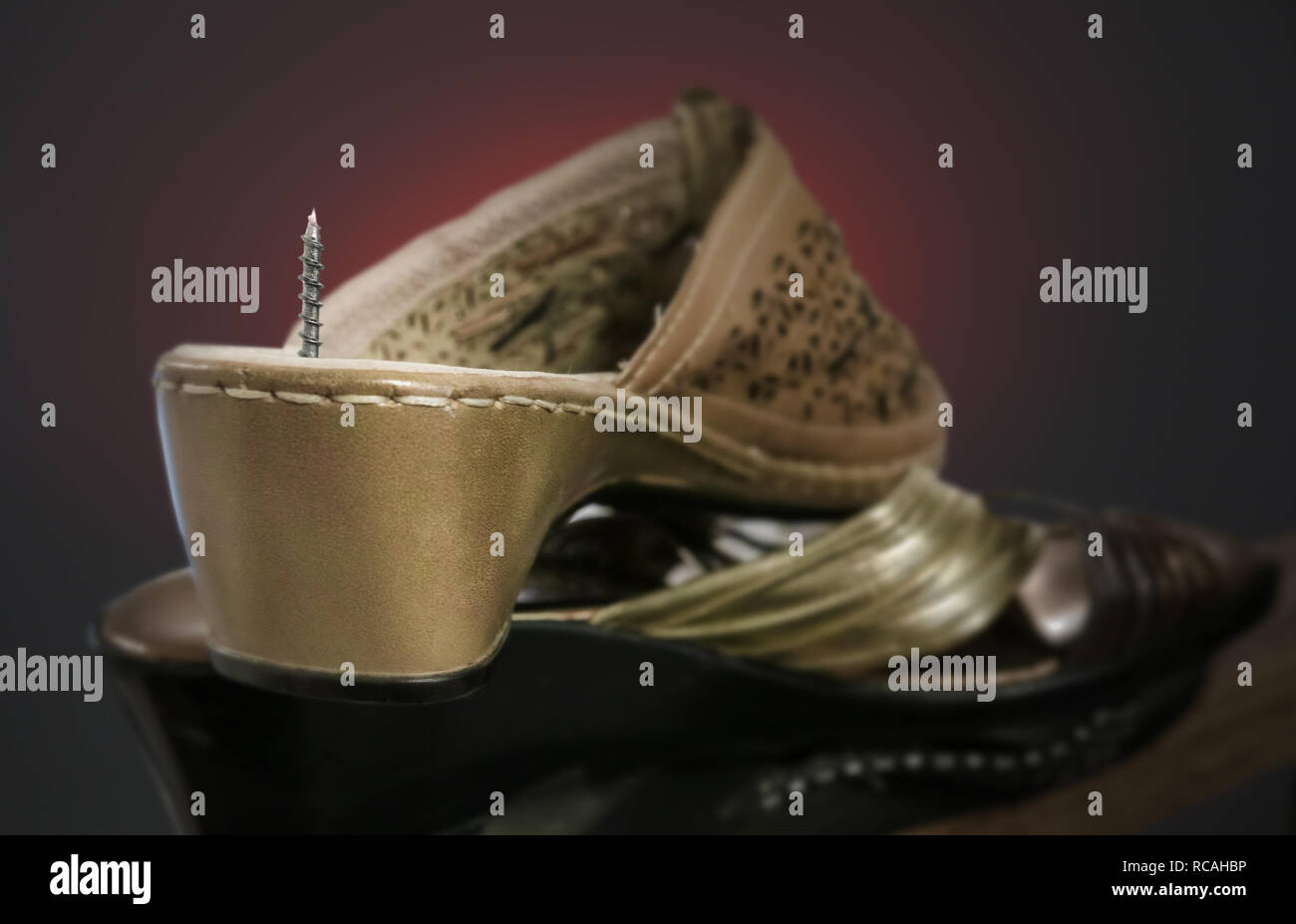 A screw passes through the sole of the shoe. Pain in the heels Stock