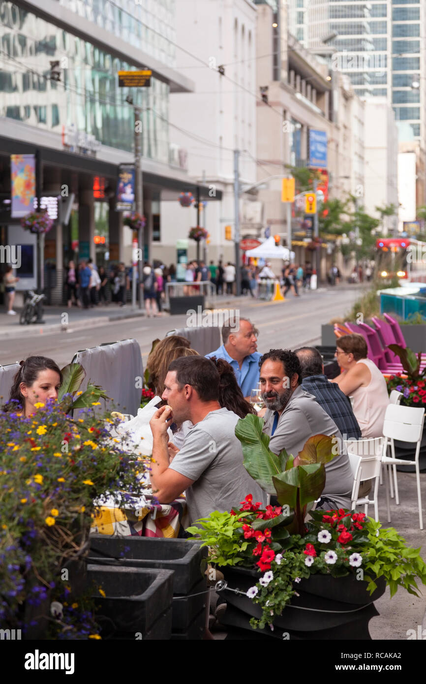 People eating at an outdoor patio along Wellington Street W. City of