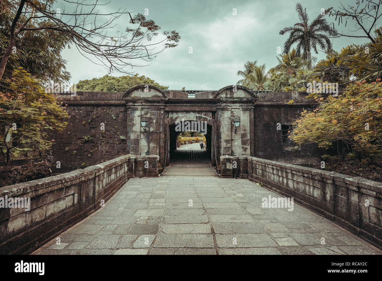 The stone bridge leading to the Fort Santiago entrance. Intramuros historic walled area. Manila, Philippine. Ancient Spanish landmark surrounded by the wild nature. The popular tourist attraction. Stock Photo