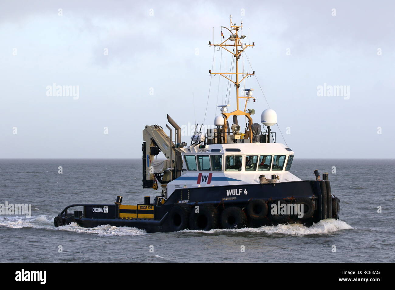 The harbor tug Wulf 4 operates on 30 December 2018 in front of the port of Cuxhaven on the Elbe. Stock Photo