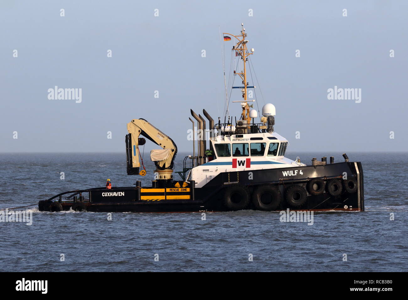 The harbor tug Wulf 4 operates on 30 December 2018 in front of the port of Cuxhaven on the Elbe. Stock Photo
