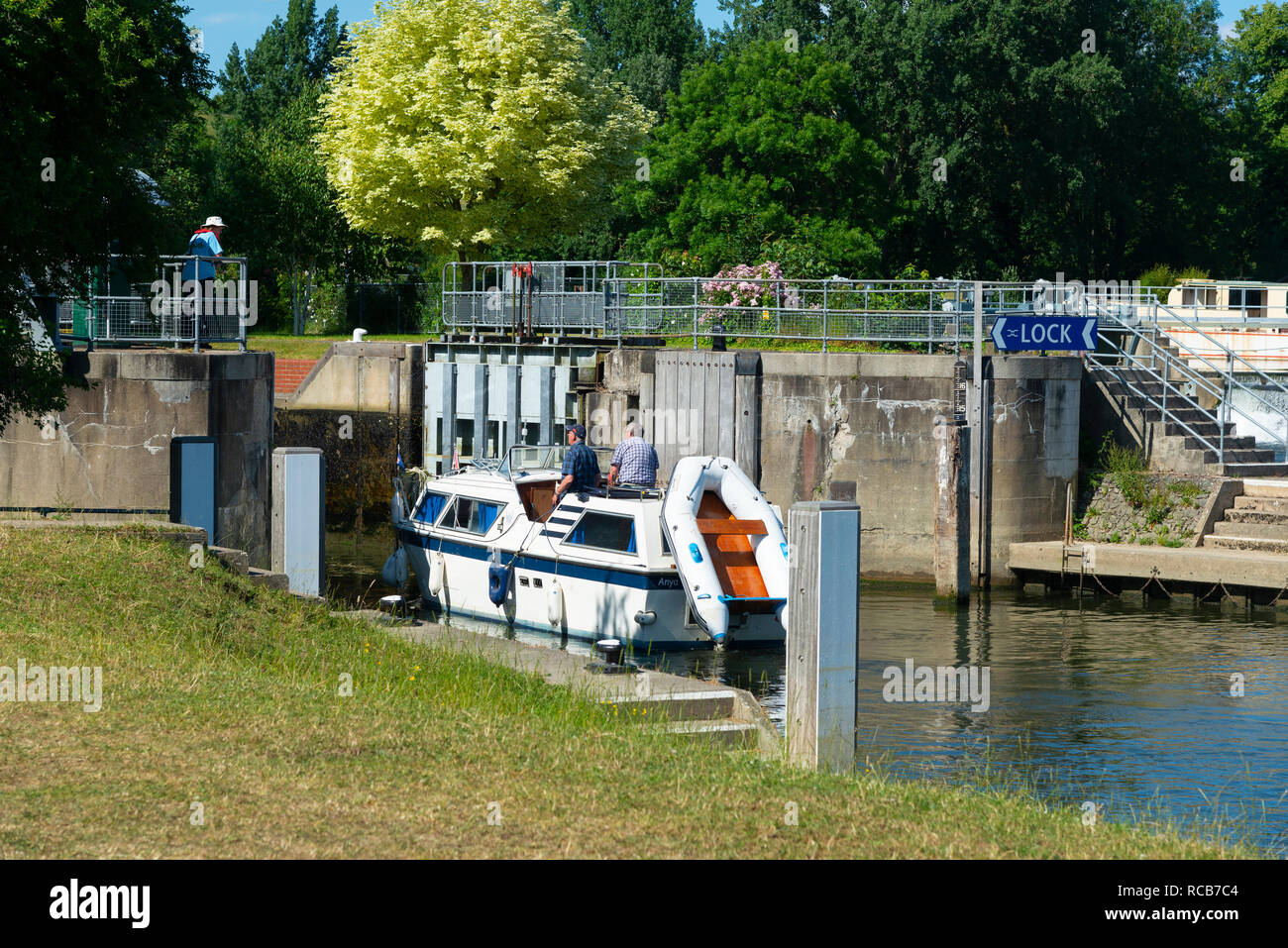 Motor boat entering Mapledurham Lock on the River Thames on a summer's day near the village of Purley-on-Thames, Berkshire, England, UK Stock Photo
