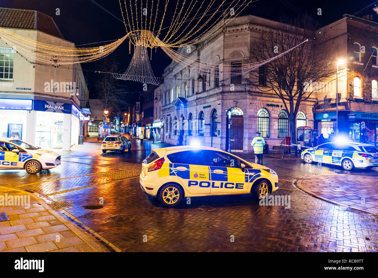 Ramsgate bomb suspected bomb incident on 14 January 2019. Police cars with blue flashing lights help cordon off the town centre, night time. Three police cars and some policemen parked on cross roads on town, city street. Stock Photo