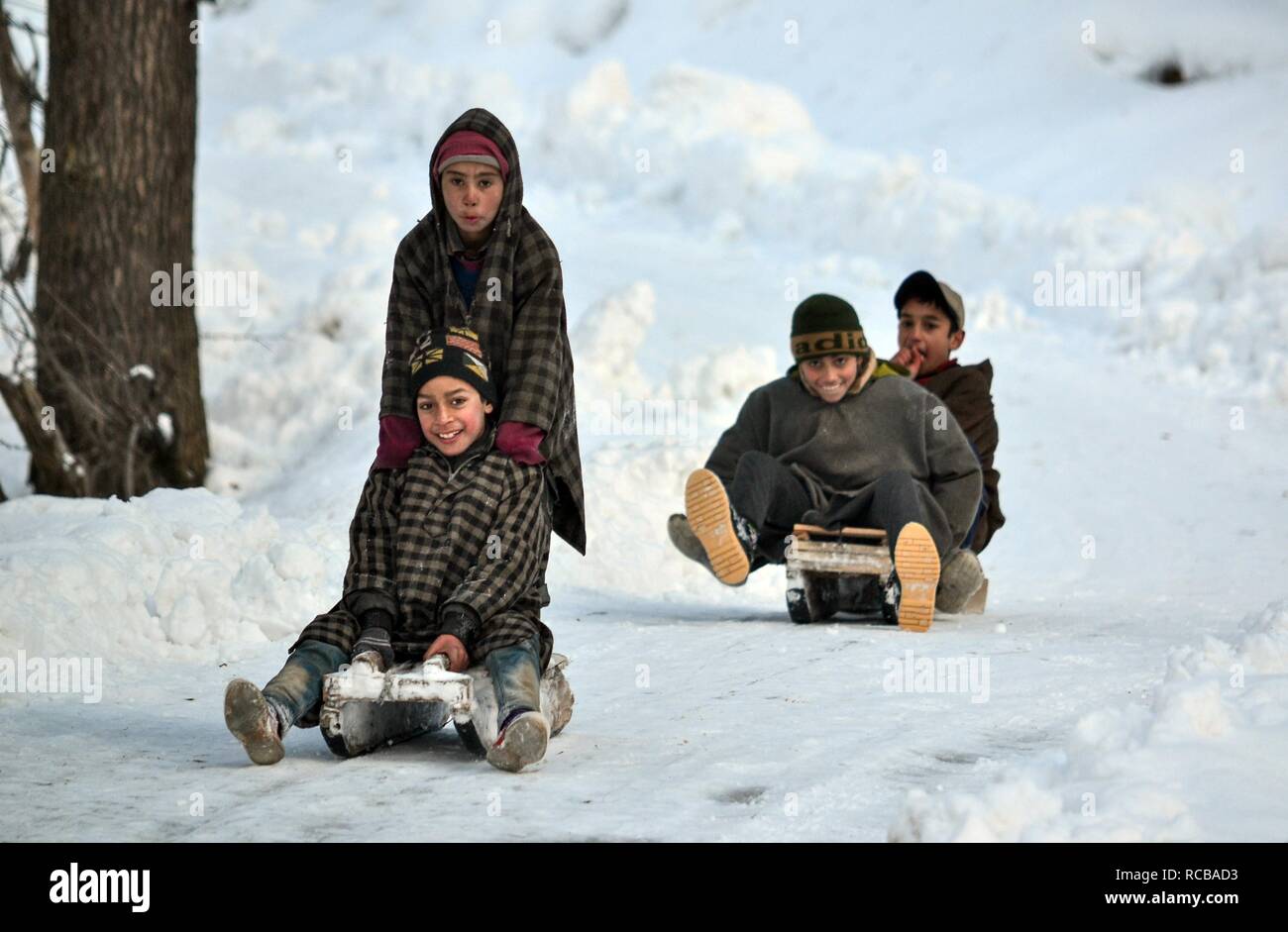 January 14, 2019 Kashmir, J&K, India Kashmiri children seen sliding down a hill on sledges