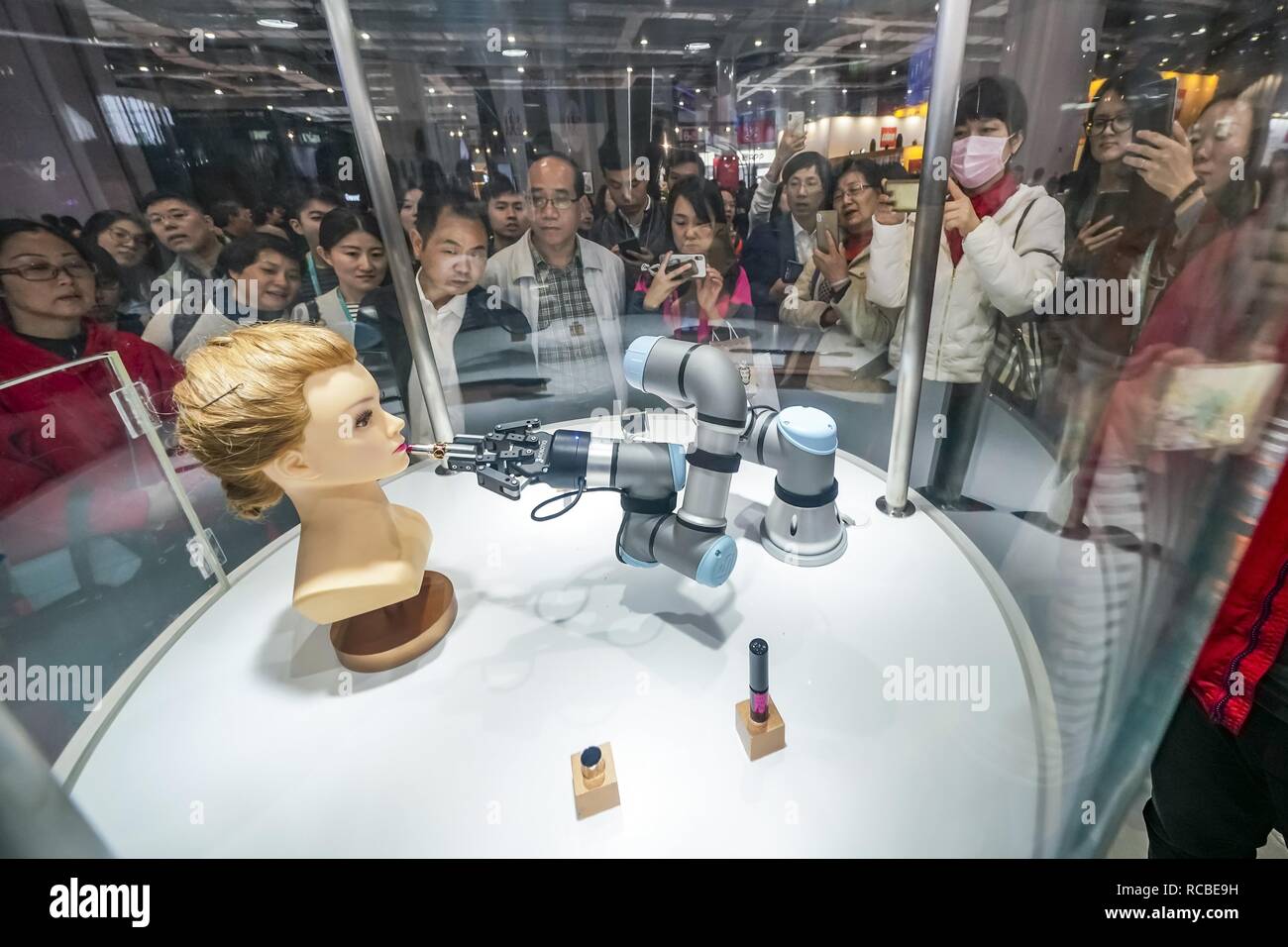 (190115) -- BEIJING, Jan. 15, 2019 (Xinhua) -- Visitors view a robot arm performing makeup tutorship at the Apparel, Accessories & Consumer Goods area of the first China International Import Expo (CIIE) in Shanghai, east China, Nov. 9, 2018. China's foreign trade rose 9.7 percent year on year to a historic high of 30.51 trillion yuan (about 4.5 trillion U.S. dollars) in 2018, the General Administration of Customs (GAC) said Monday. Exports rose 7.1 percent year on year to 16.42 trillion yuan last year, while imports grew 12.9 percent to 14.09 trillion yuan, resulting in a trade surplus Stock Photo