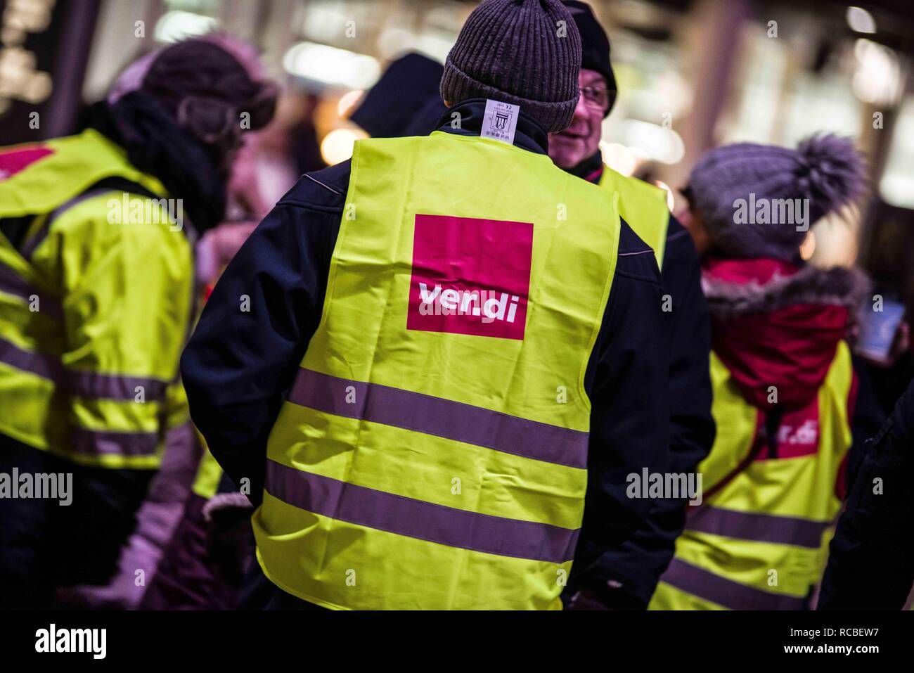 Munich, Bavaria, Germany. 15th Jan, 2019. The logo of the Verdi union worn by a striking security worker at Munich International Airport. Citing a breakdown in talks with employers on December 21st, the German Ver.di union organized the latest warning strike in a series at the Munich International Airport with members employed in Airport Security Services (Luftsicherheit) walking out from 3:30am to 24:00. The union is demanding 20 Euros per hour for their 1,000 total members working in Passenger-, Freight, Personnel, and Goods Control of Airport Security, along with recertification to br Stock Photo