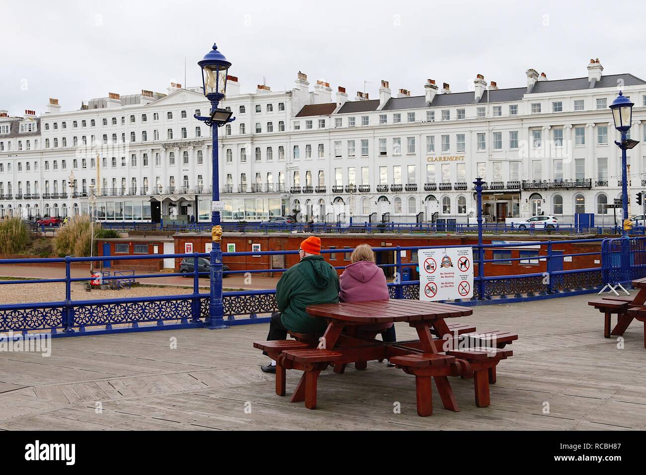 Eastbourne, East Sussex, UK. 15 Jan, 2019. UK Weather: A bright but chilly mid morning in Eastbourne on the seafront promenade with people jogging and taking a walk enjoying the dry weather. An older couple sit on a bench looking at the hotels on the beach front including the claremont. © Paul Lawrenson 2018, Photo Credit: Paul Lawrenson / Alamy Live News Stock Photo