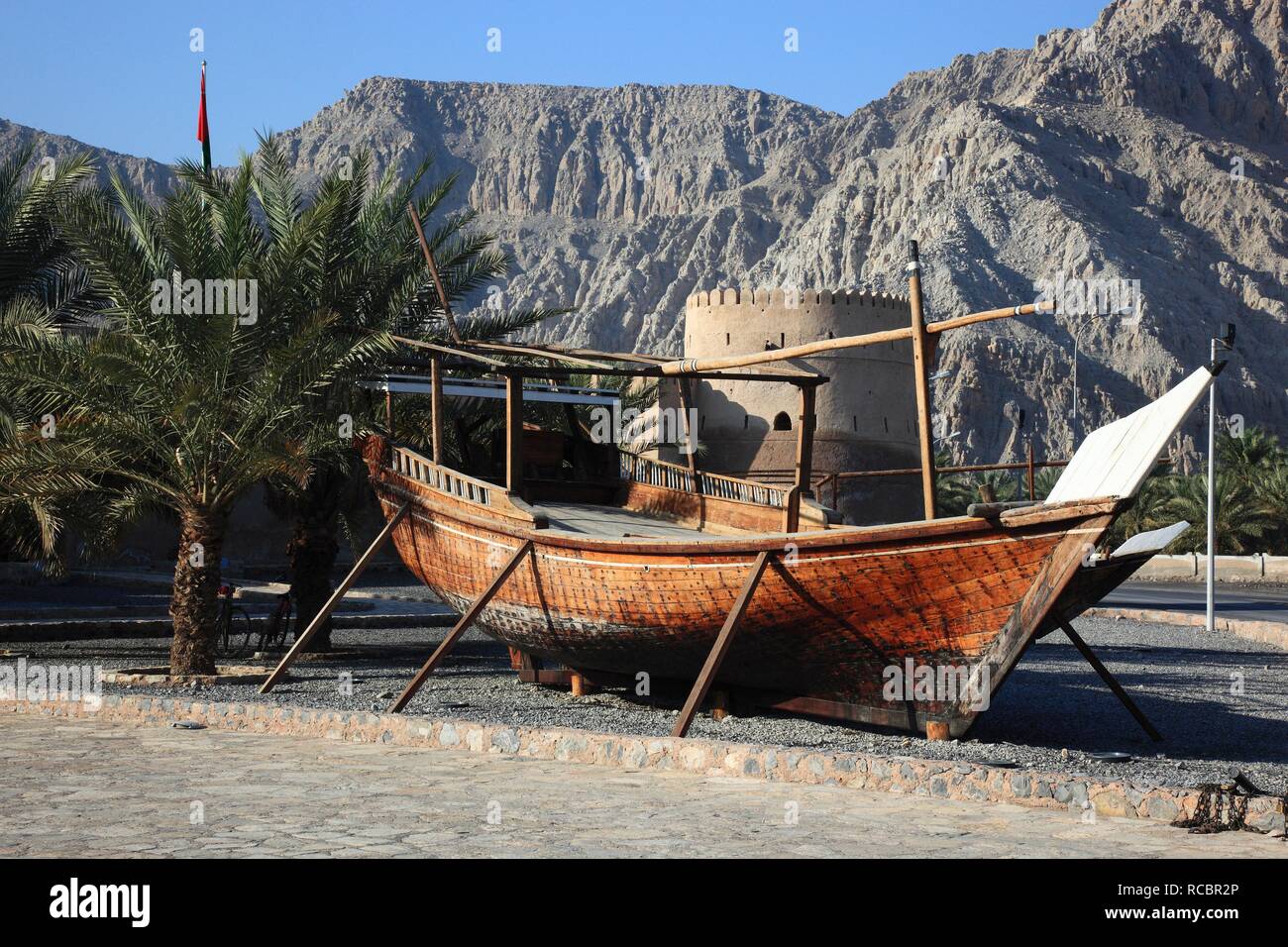 Dhow, a traditional wooden boat, in front of Cacapo Fort, al-Khasab, Khasab, in the Omani enclave of Musandam, Oman, Middle East Stock Photo
